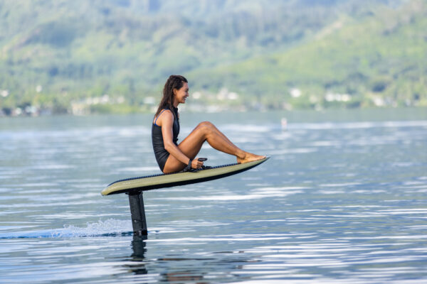 Green Fliteboard PRO gracefully gliding on a serene lake, its vibrant color accentuating its sleek design and exhilarating performance with a touch of natural allure.