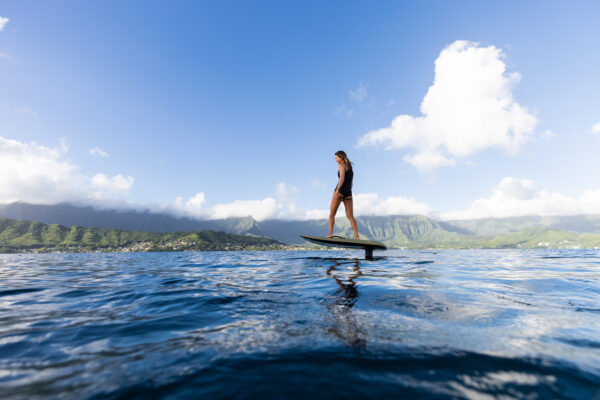 Adventurous girl enjoying the thrill of riding a Fliteboard on a serene lake.