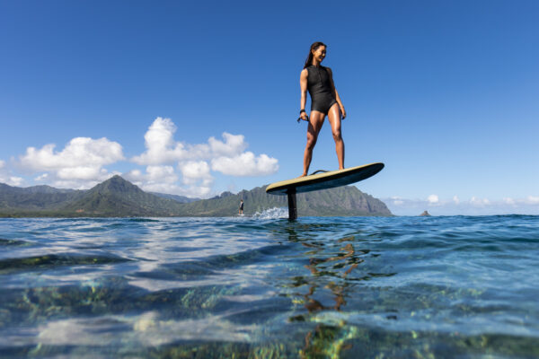 A woman soaring high on a Fliteboard - Experience the thrill of flight and empower your hydrofoil adventure with the Fliteboard's unmatched performance and stability.