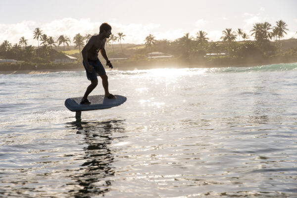 A stunning silver Fliteboard ULTRA, a sleek and electric hydrofoil surfboard. Its silver metallic finish shines in the sunlight, reflecting a sense of elegance and modernity. The hydrofoil underneath the board is ready to lift riders above the water's surface, offering an exhilarating water sport experience. The silver Fliteboard ULTRA combines style and performance for a captivating ride on the waves