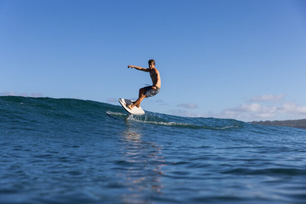 Man riding the Fliteboard ULTRA, showcasing its dynamic performance and sleek design as he carves through the waves with precision and speed.